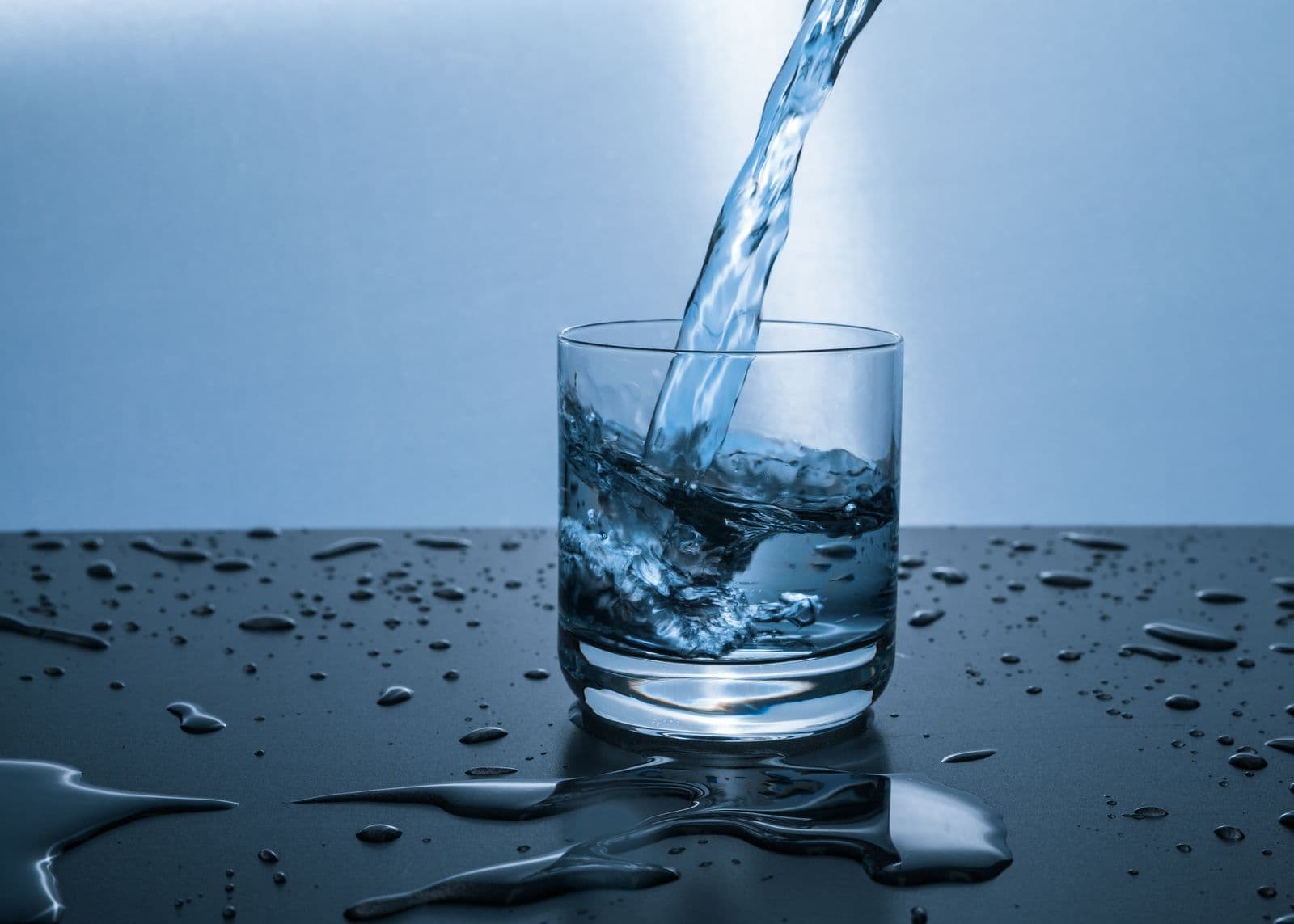 Clear drinking water being poured into a glass. Stock photograph.